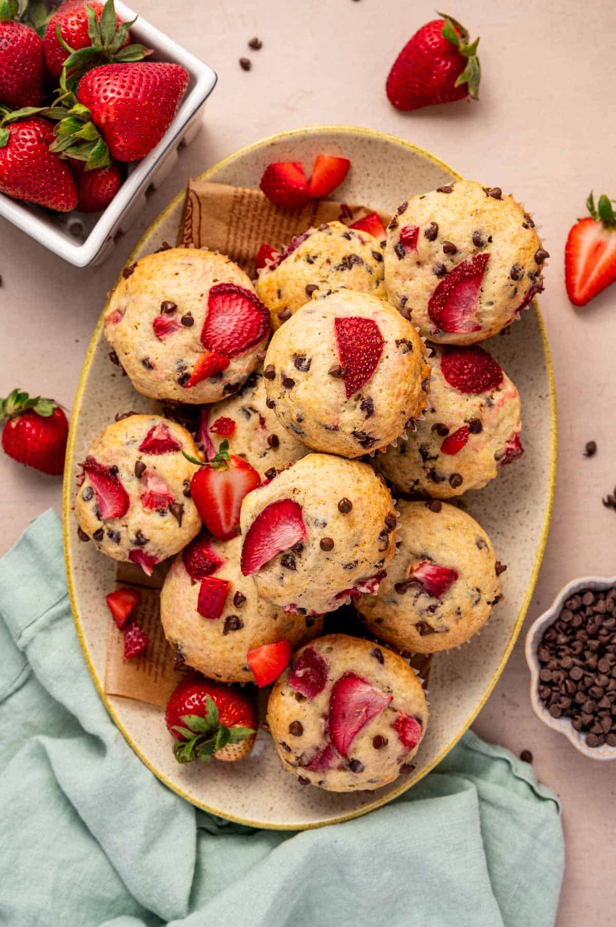 A oval platter filled with moist strawberry muffin with melted mini chocolate chips.