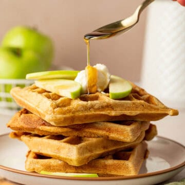 Freshly made apple cinnamon waffles with maple syrup drizzle.