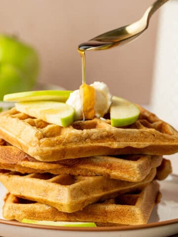Freshly made apple cinnamon waffles with maple syrup drizzle.