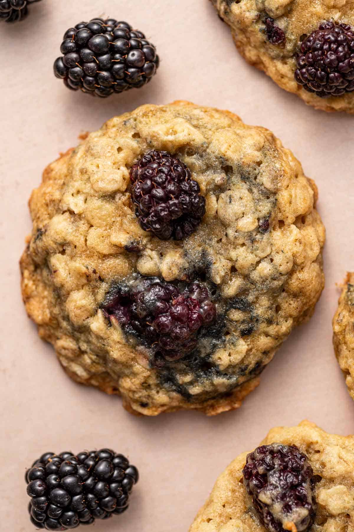Overhead shot of homemade blackberry oatmeal cookies with fresh berries around.