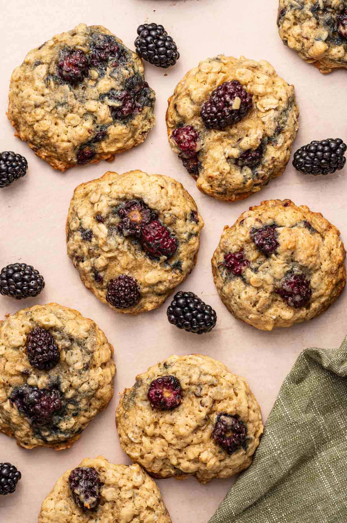 Overhead shot of Golden brown oatmeal cookies with juicy blackberries inside.