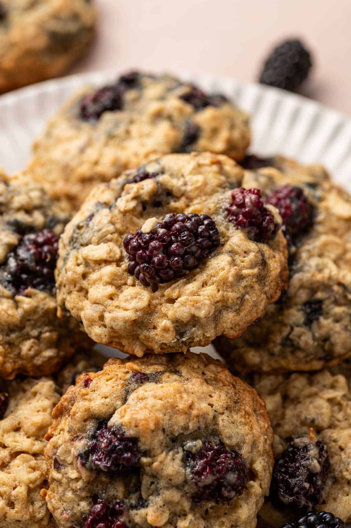 Close-up of soft and chewy blackberry oatmeal cookies with rolled oats.