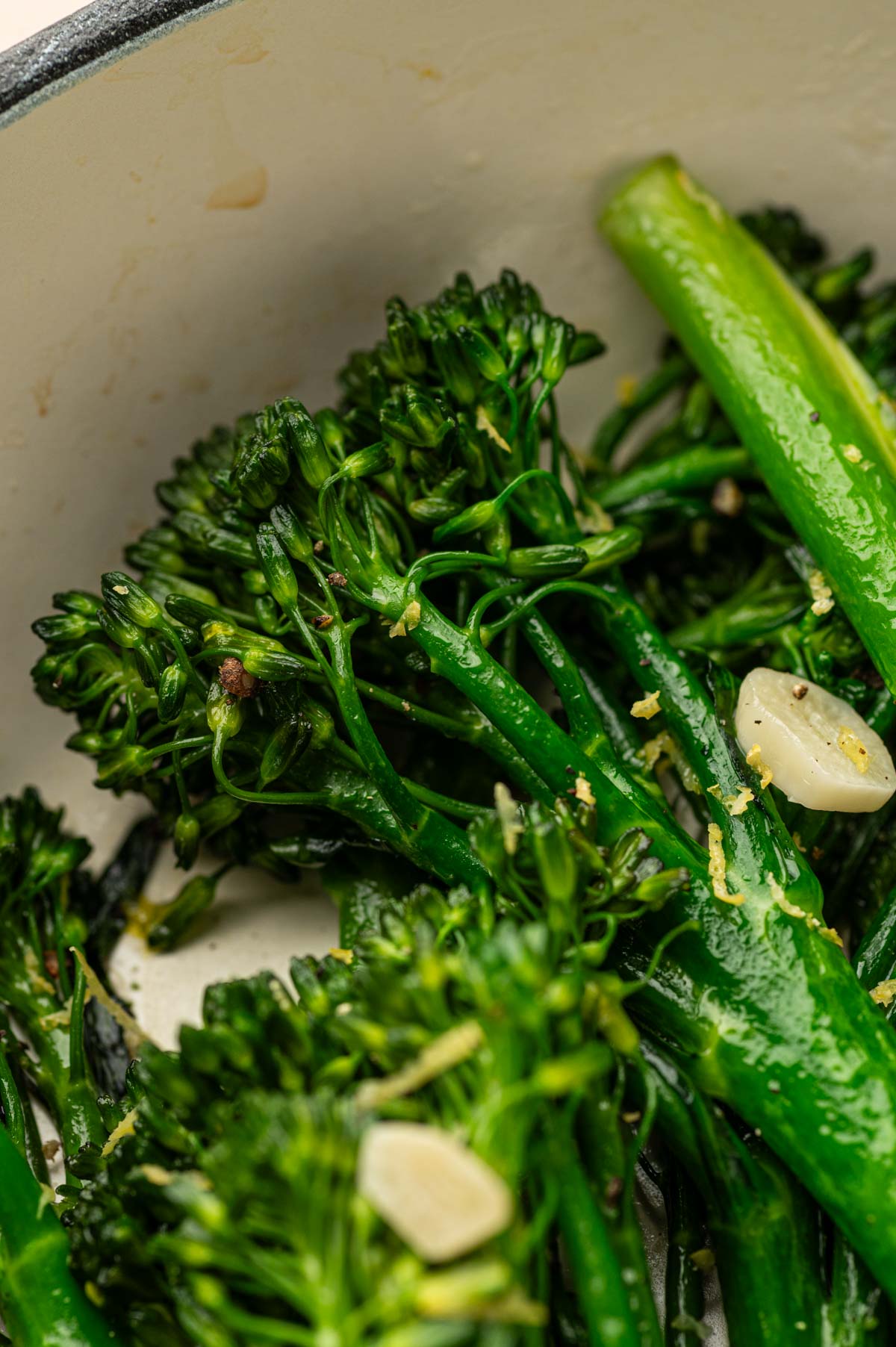 Close-up of tender broccoletti cooked with olive oil in a skillet.