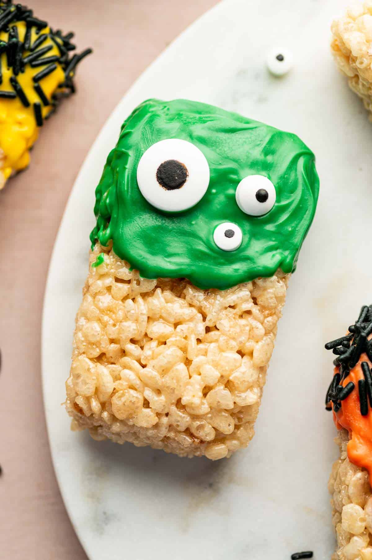 Rice Krispie Treats cut into fun Halloween shapes, decorated with green icing and mini candy eyeballs.