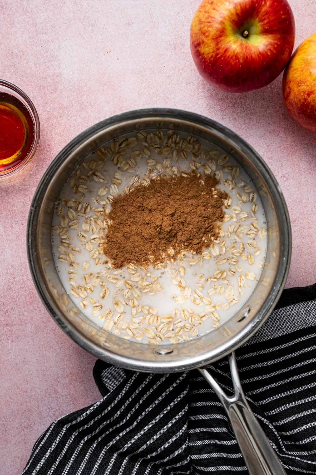 Saucepan of apple cinnamon oatmeal simmering on the stovetop.