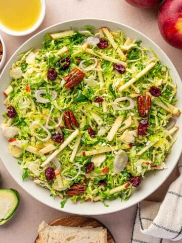 Healthy Brussels sprouts salad with maple Dijon vinaigrette, cranberries, and shallots.