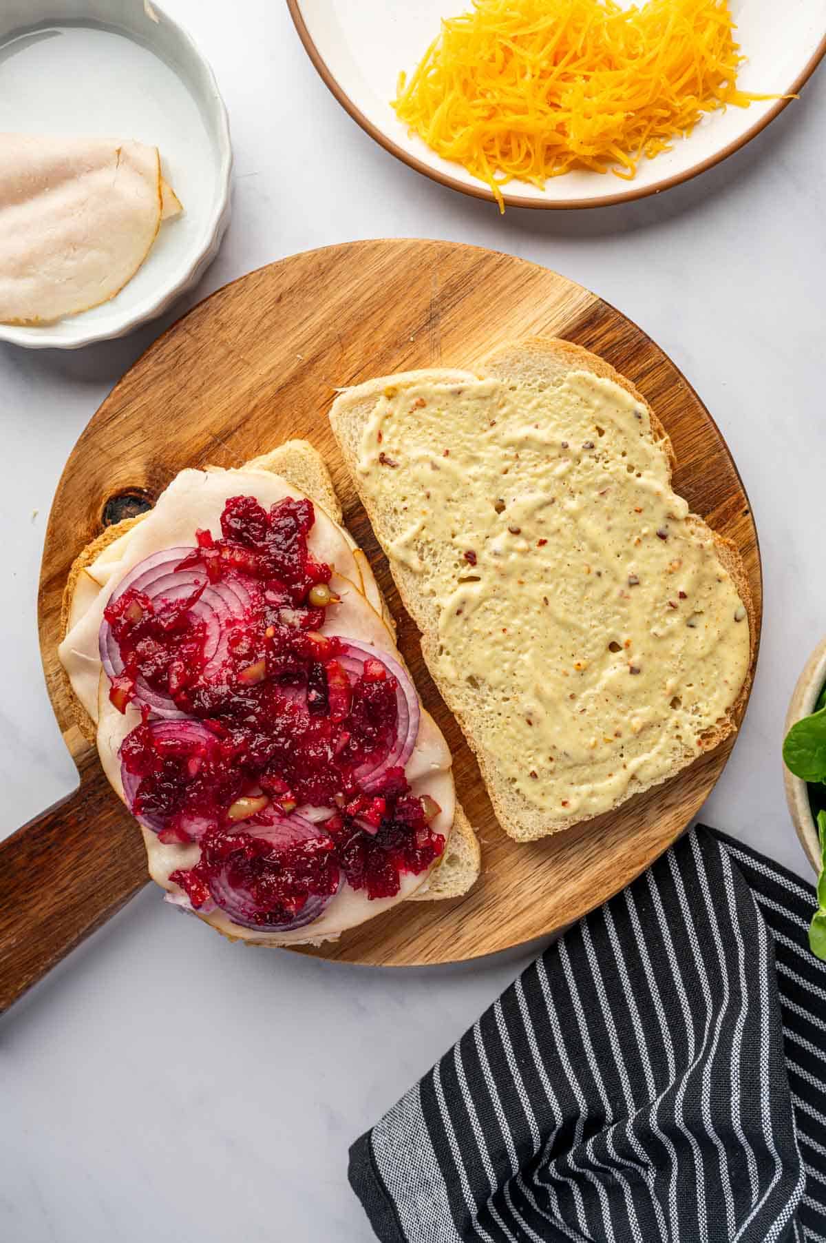Cranberry relish being spread over the bread.