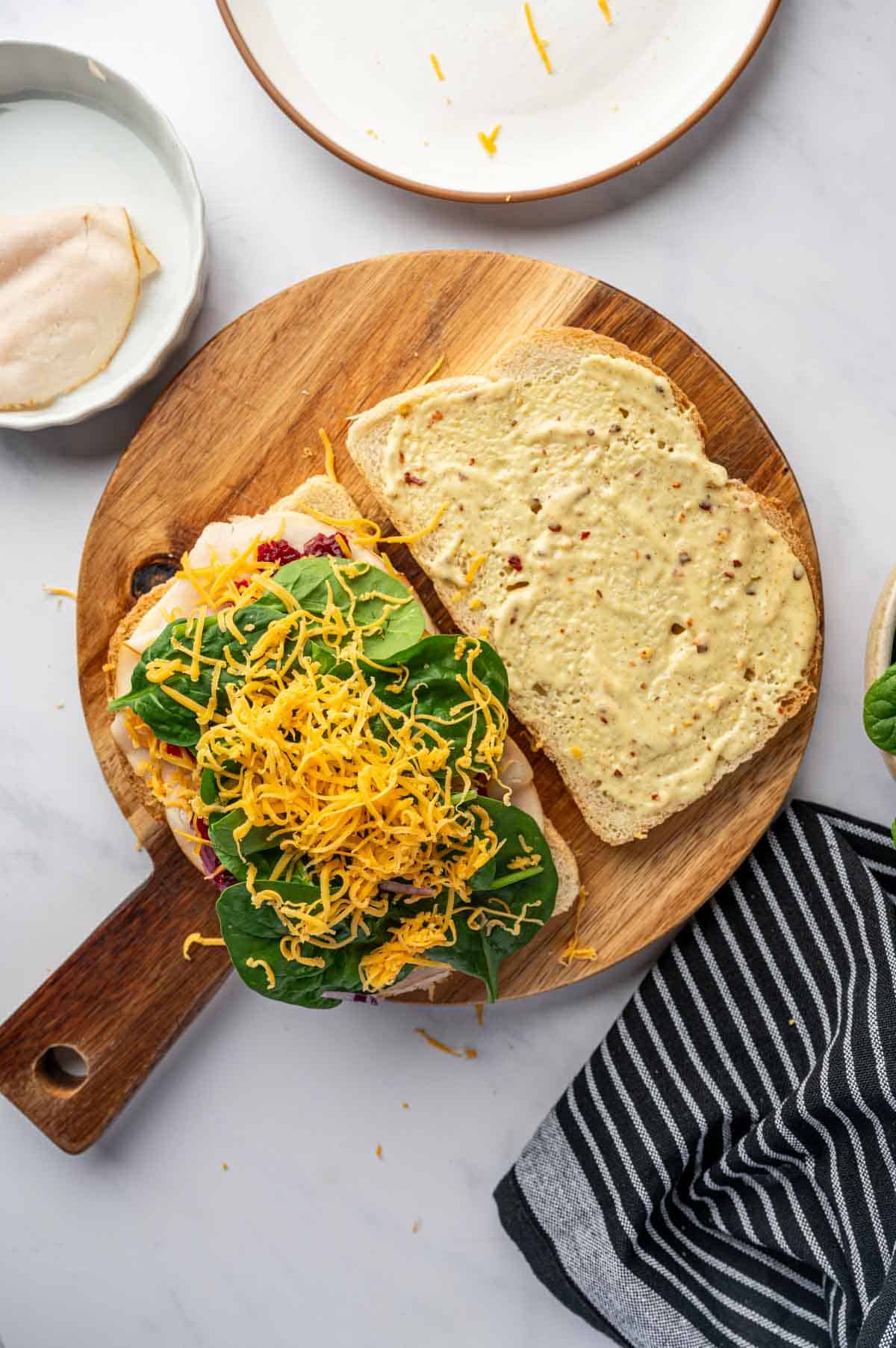 Veegies being arranged on topped with cheddar cheese.