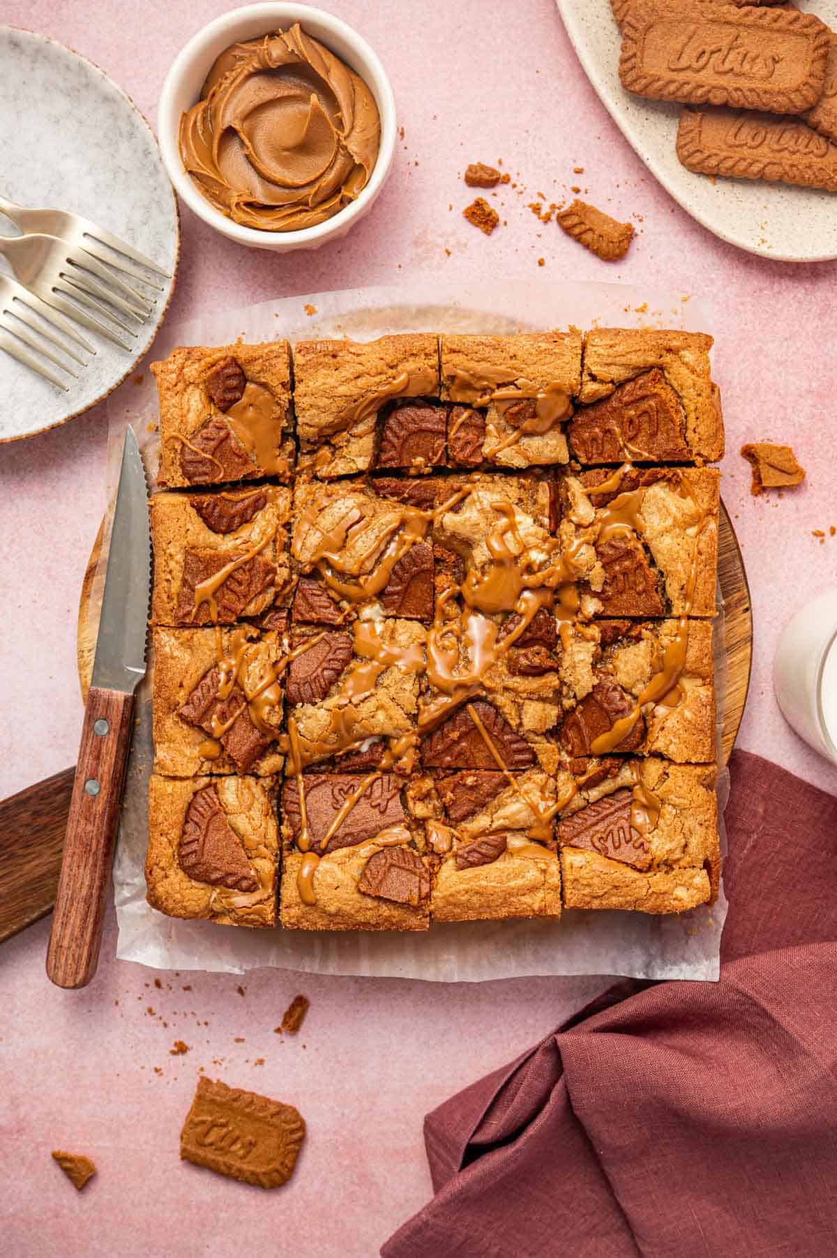 Overhead shot of biscoff blondies in a parchment paper with crunchy biscoff cookie pieces on top.