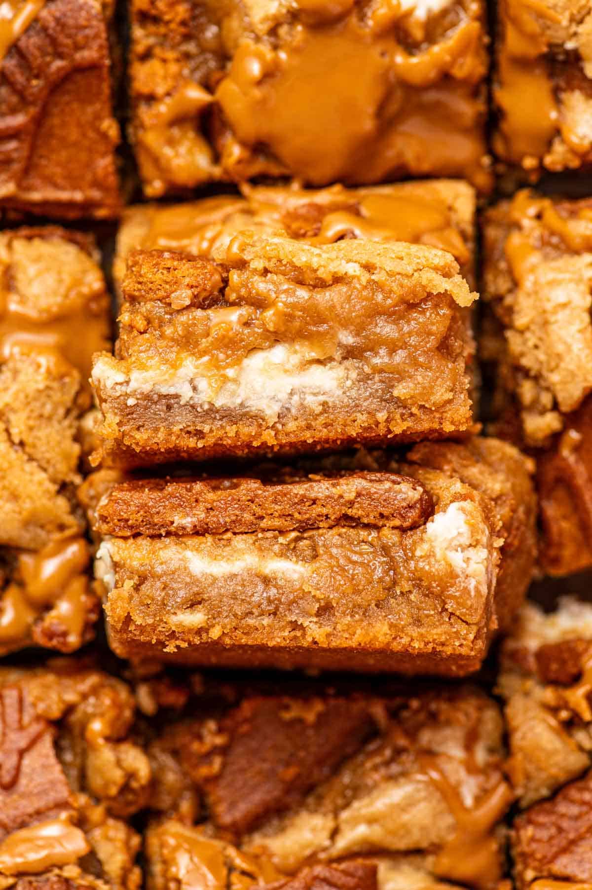 Soft, chewy biscoff blondies stacked on top of each other showing gooey texture.