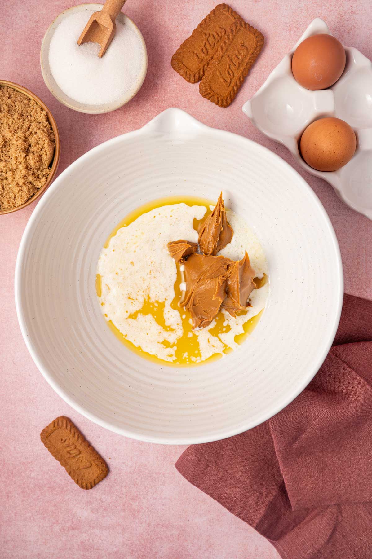 Wet ingredients being added to the bowl to make biscoff blondies