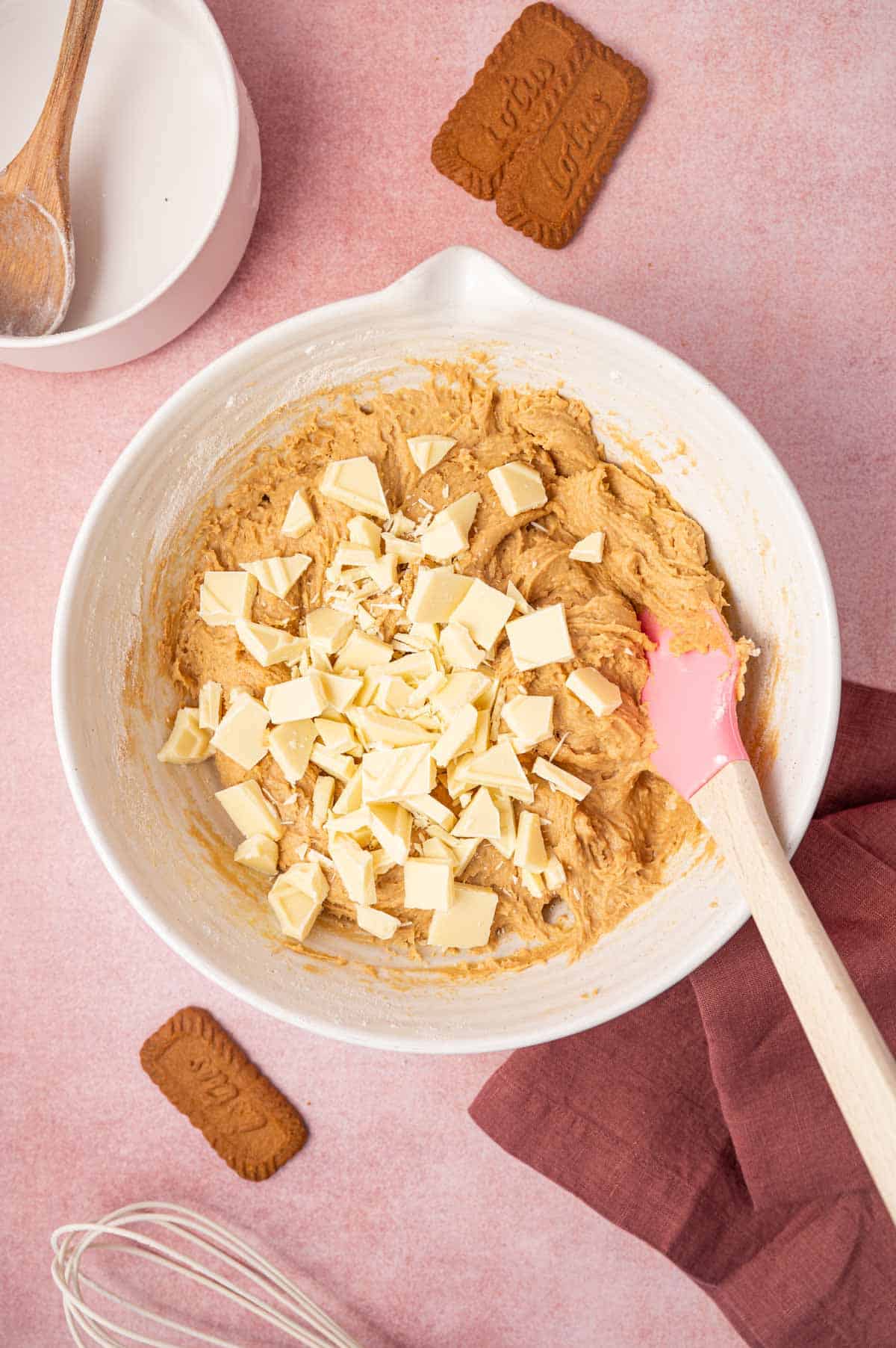 Chopped white chocolate bar being added to the biscoff blondie batter.