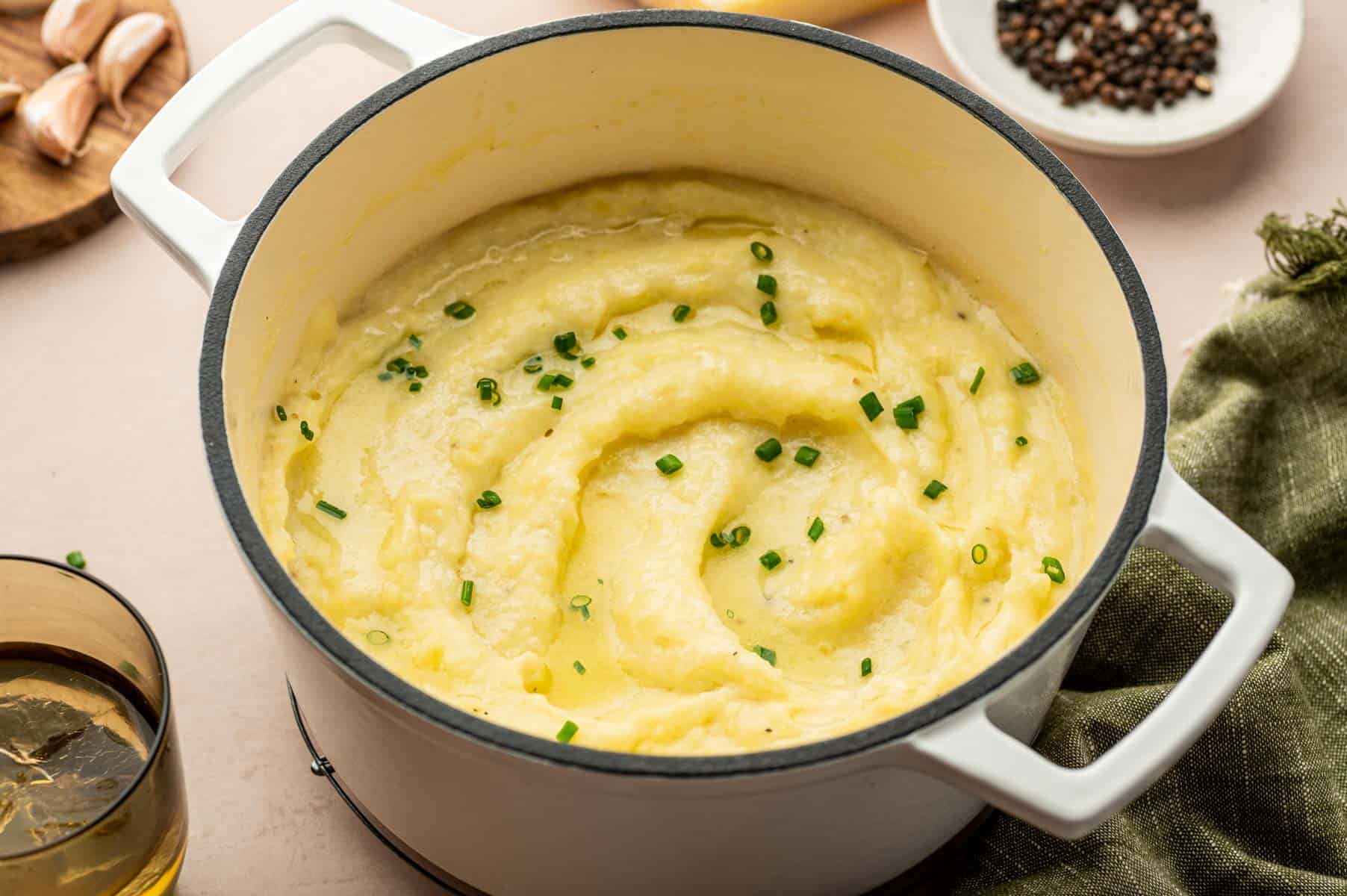 Close-up of fluffy mashed potatoes blended with cheese, garlic, and sour cream on a wooden table.