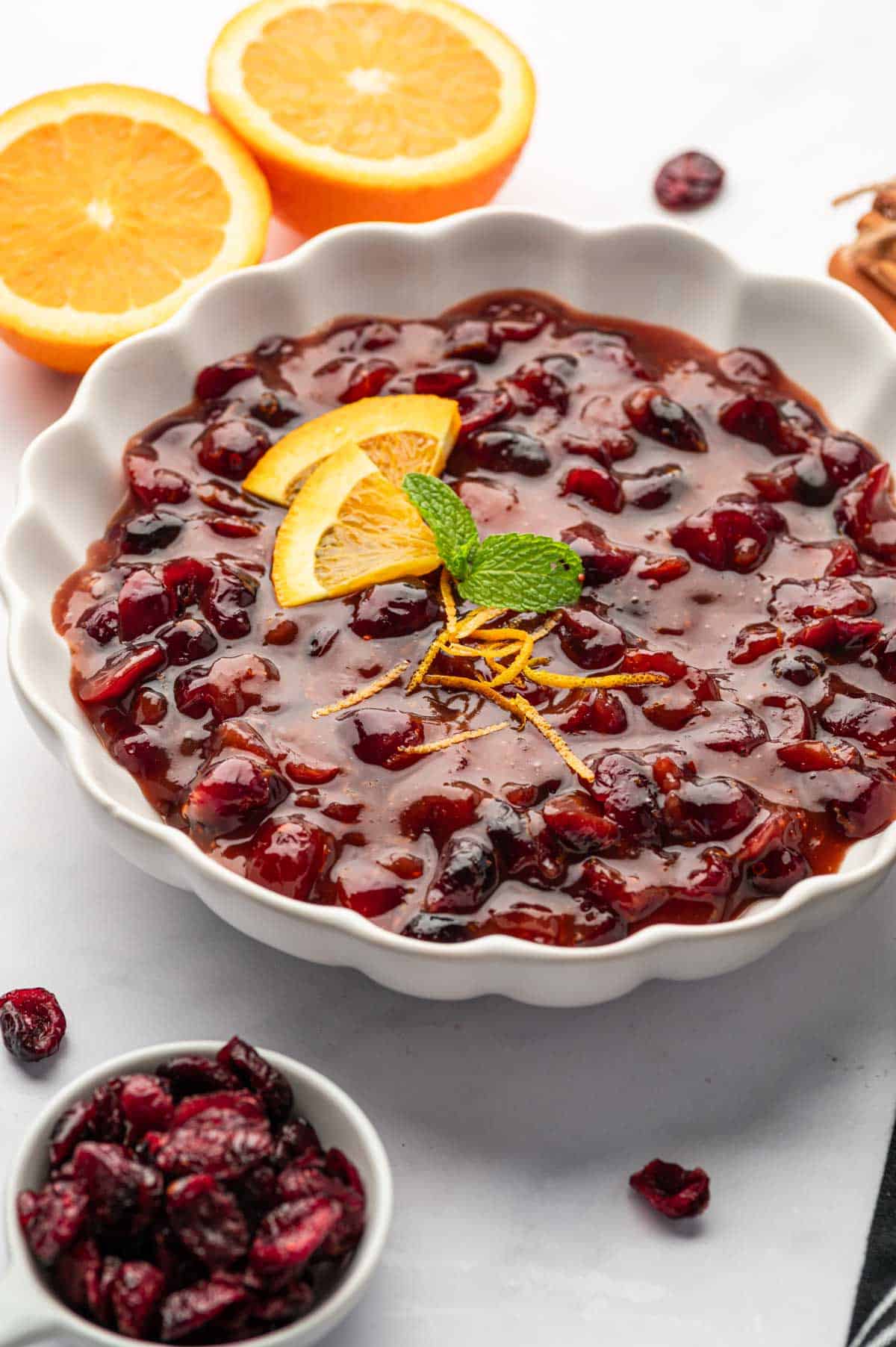 Homemade cranberry sauce made with dried cranberries served in a white bowl on a holiday table.