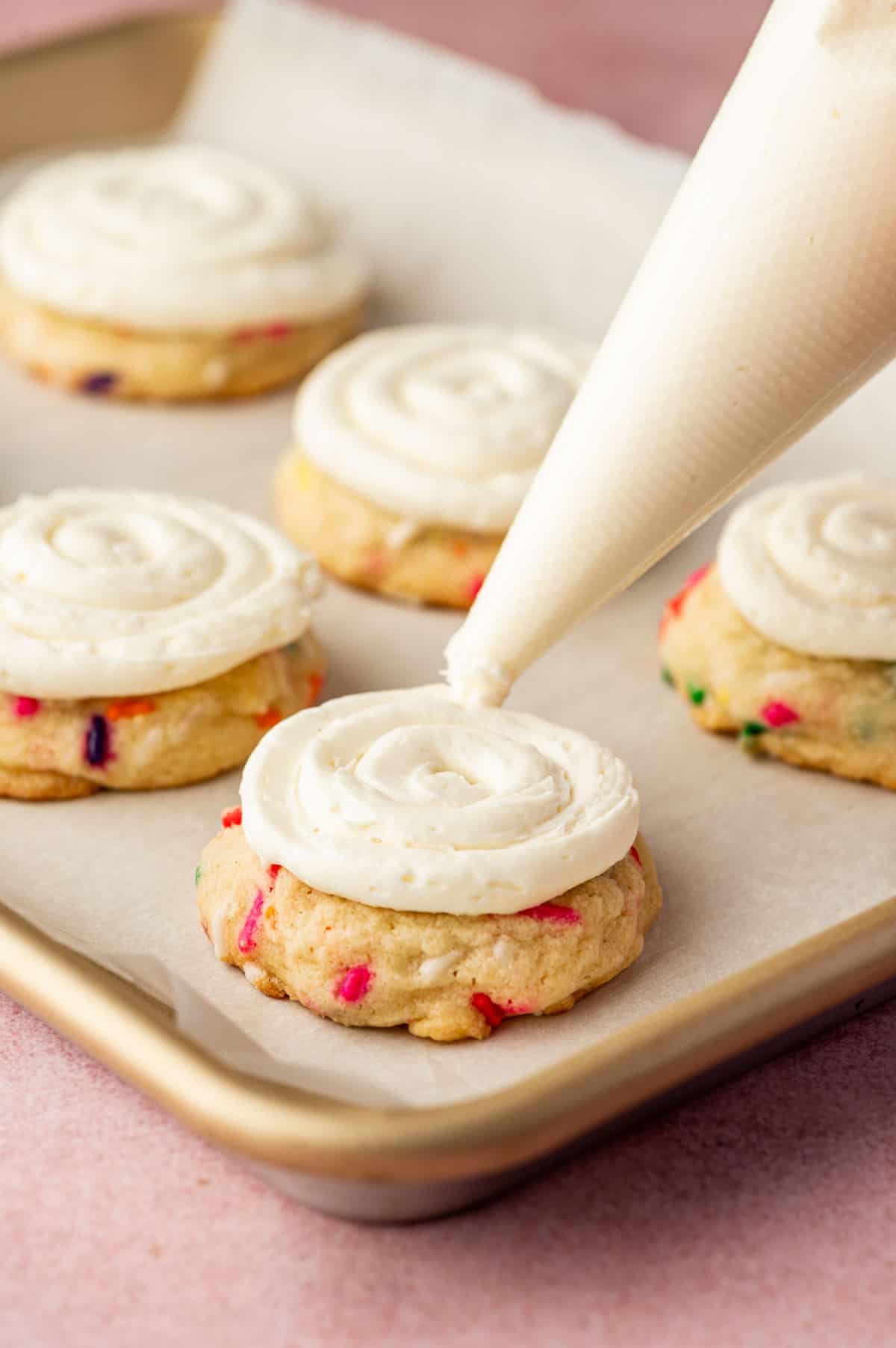 Buttercream frosting being decorated on the baked cookies.