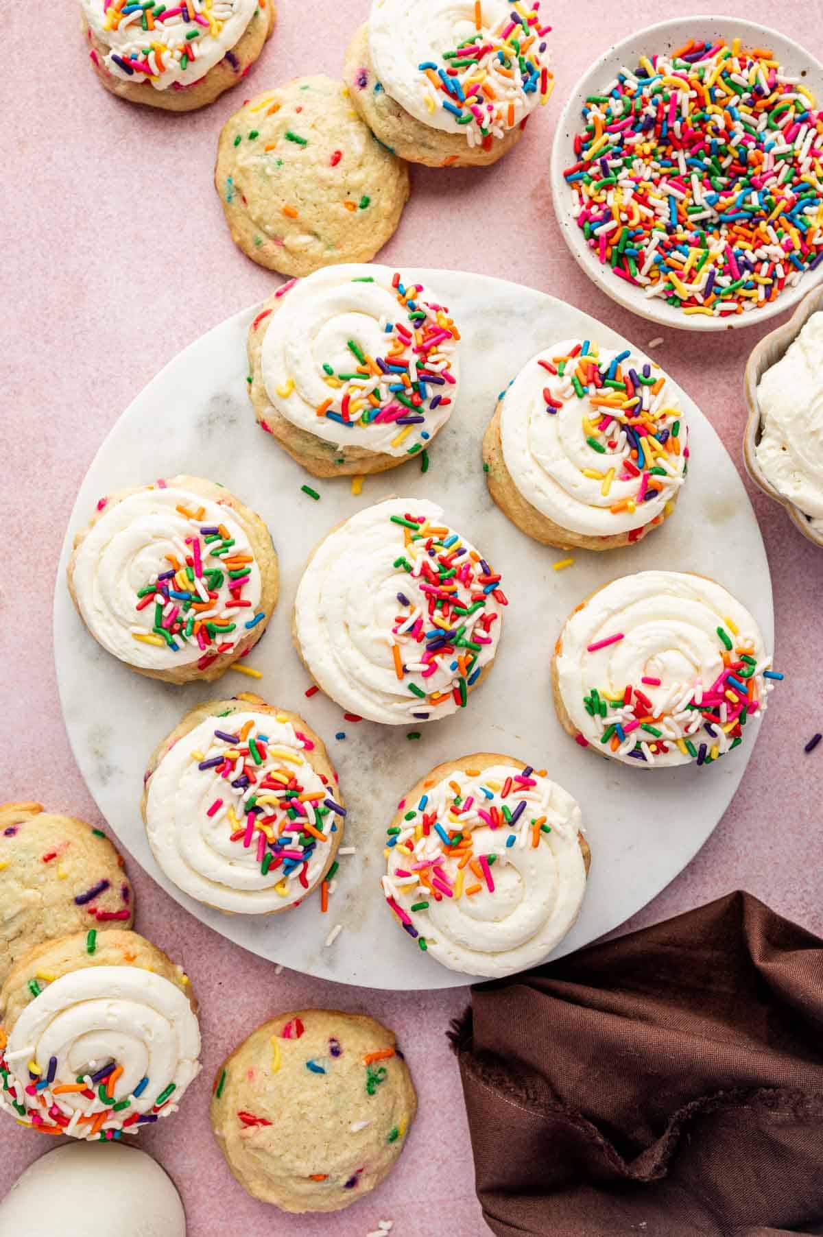 Overhead platter of funfetti birthday cookies with cream cheese buttercream swirls and sprinkled with funfetti