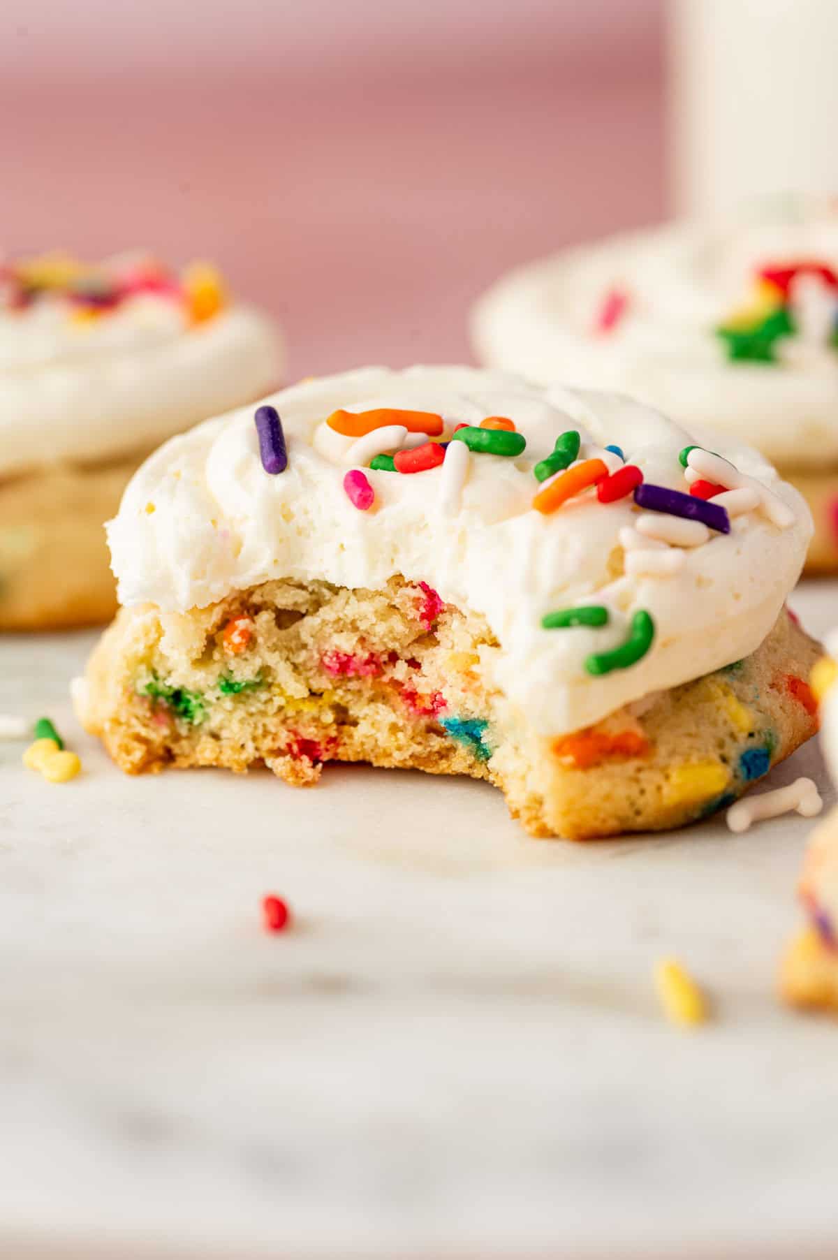 Close-up shot of showing textures of chewy funfetti cookie topped with vanilla buttercream and confetti.