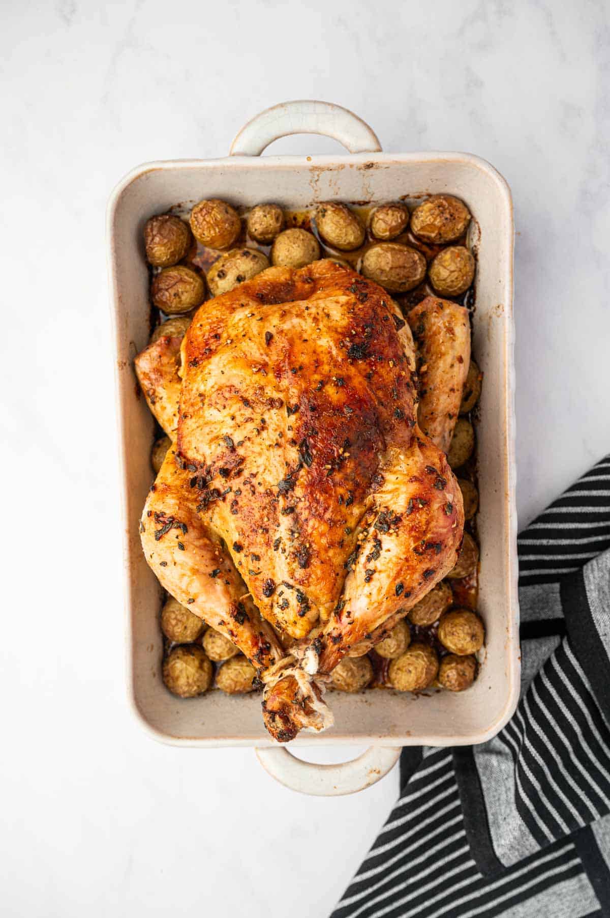 Roasted whole chicken and potatoes are placed in a cooling to cool down.