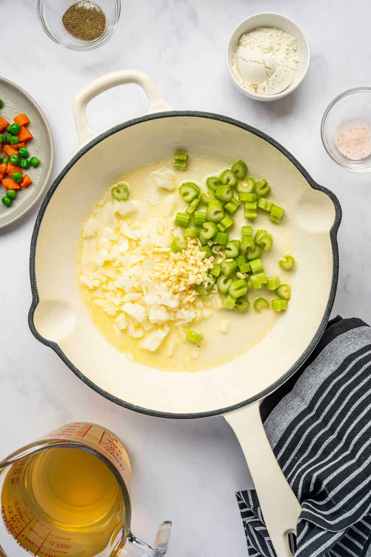 In a skillet onion, celery and garlic being ready for sautéed.