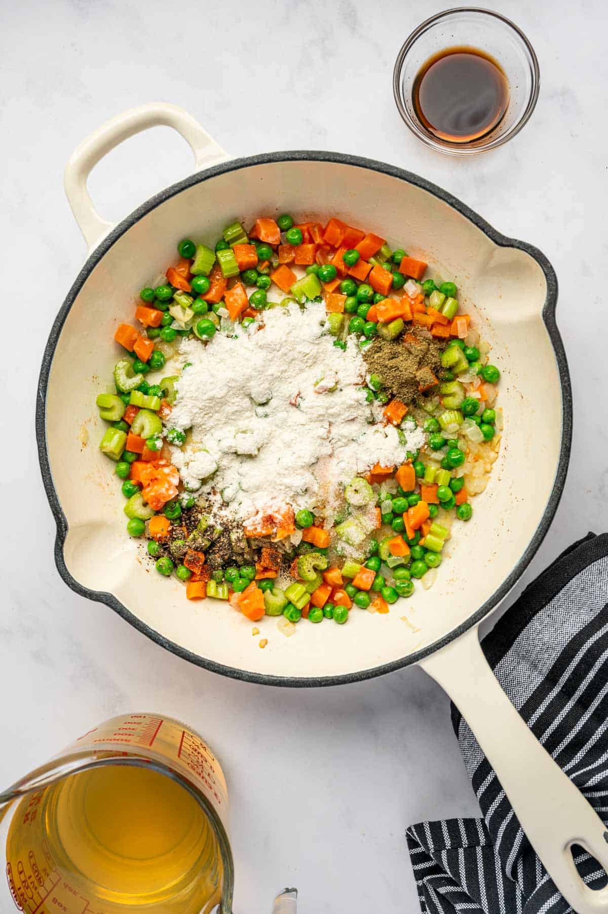 Flour and seasonings sprinkled over the veggies in the skillet.