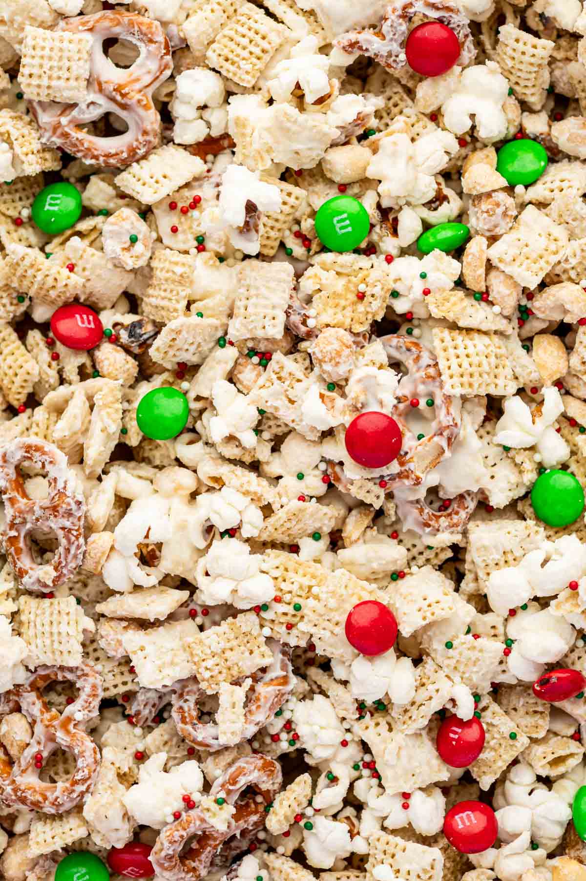 Close-up of sweet and salty Christmas Crunch, showing popcorn, pretzels, and colorful holiday M&Ms.