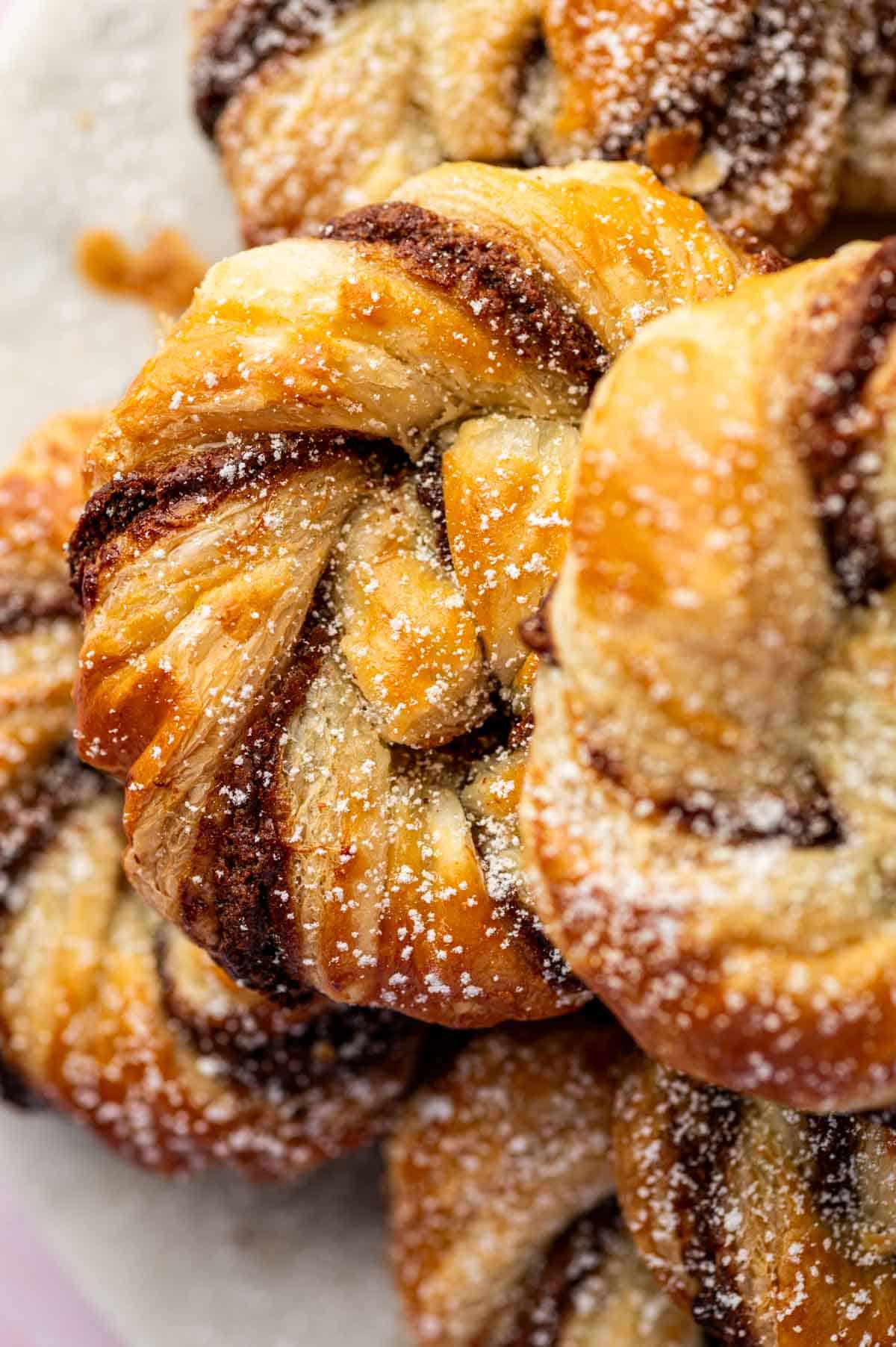 Close-up of Nutella puff pastry braid with flaky golden layers and creamy Nutella swirls.