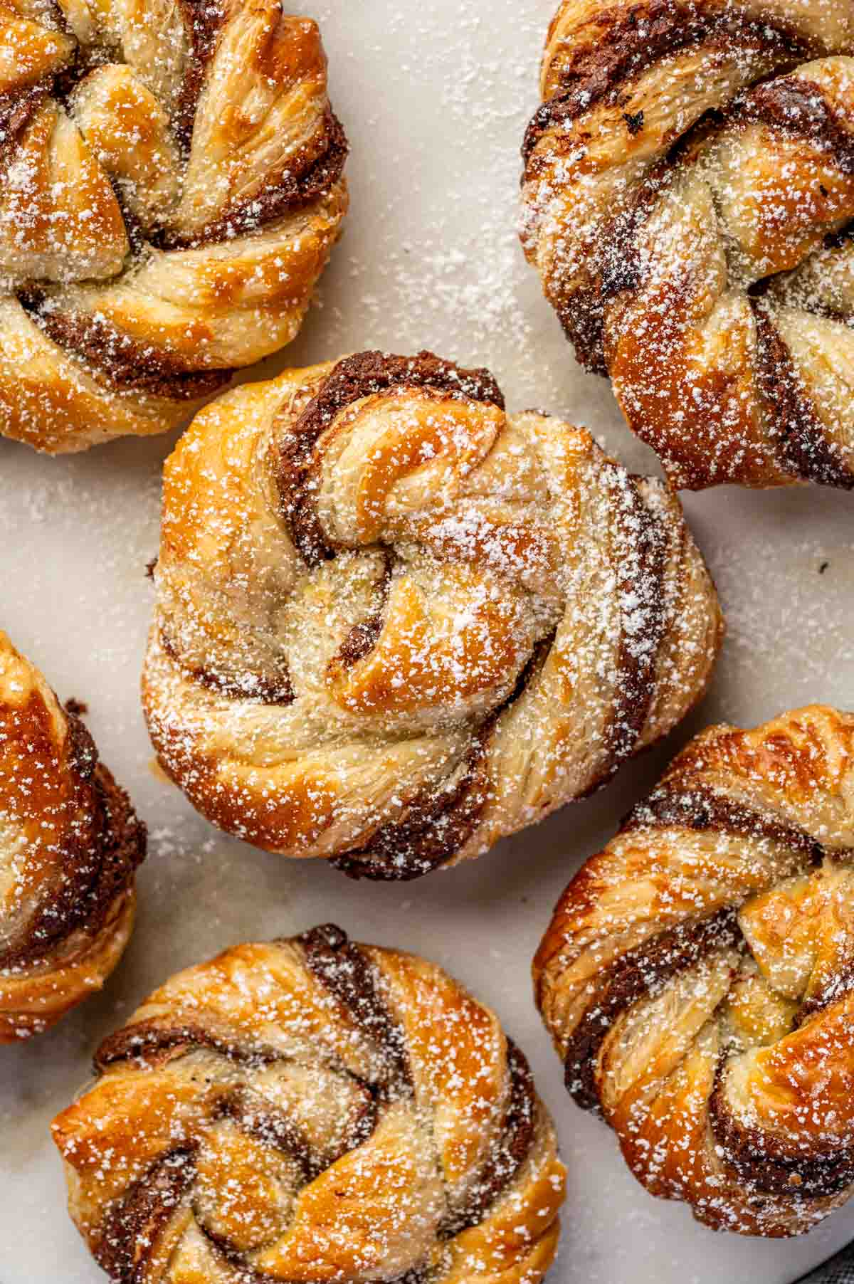 Overhead shot of flaky puff pastry filled with Nutella, dusted with powdered sugar.