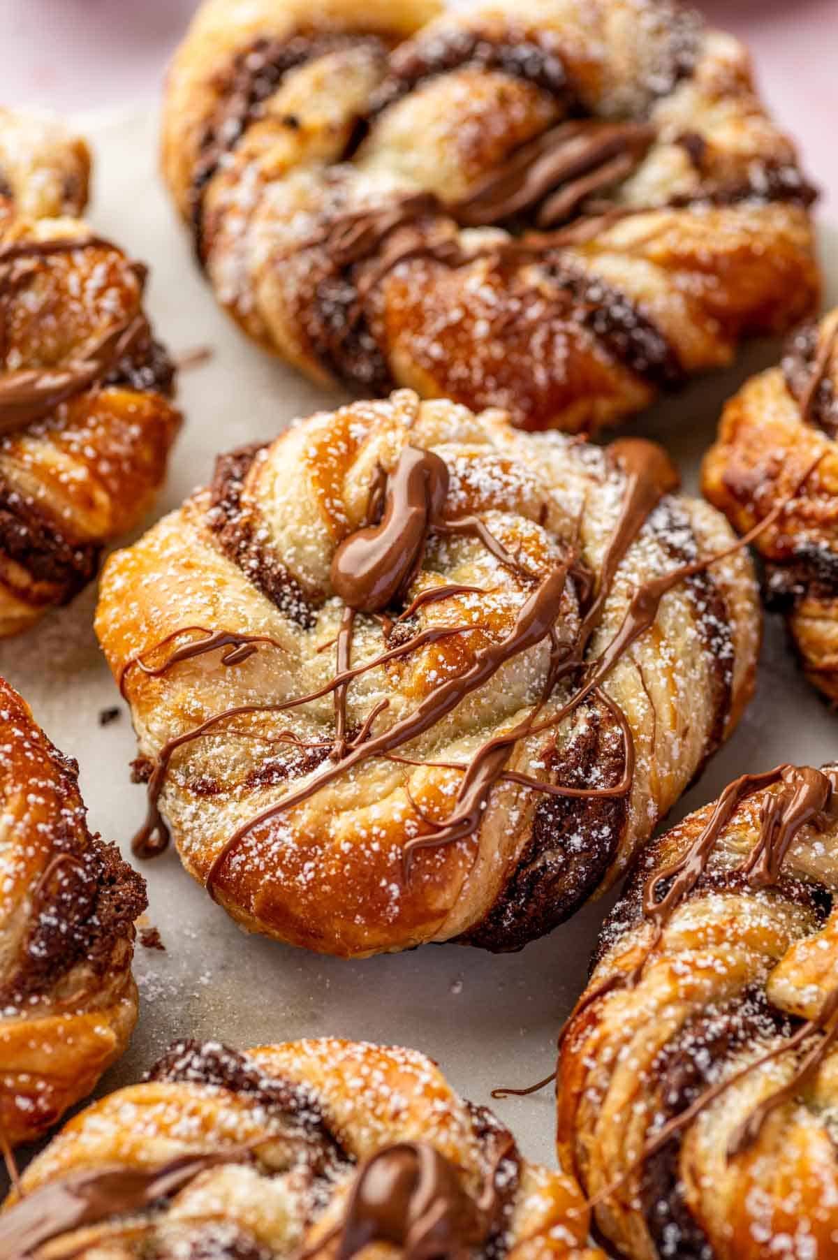 Close-up of Nutella puff pastry braid with flaky golden layers and creamy Nutella swirls.