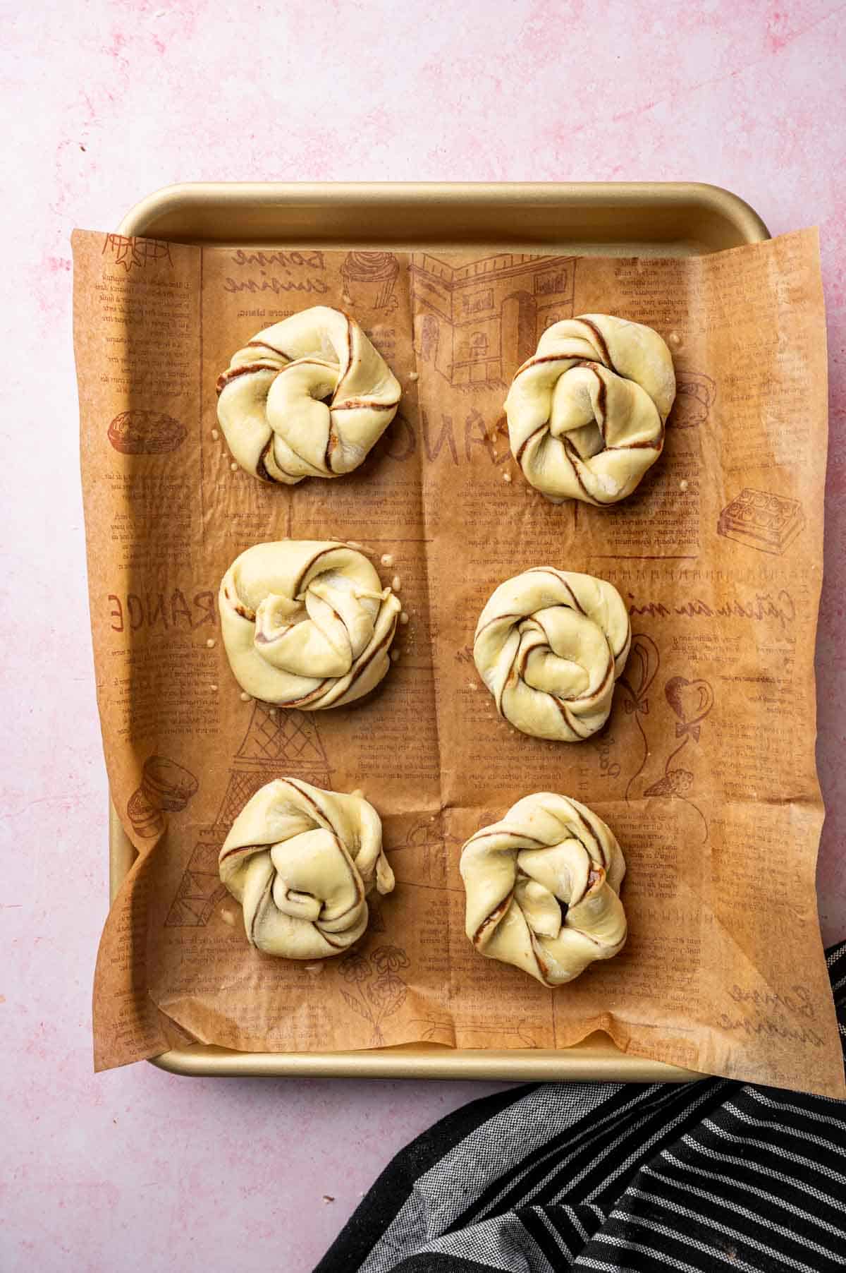 Overhead shot of flaky puff pastry filled with Nutella, placed in a baking sheet and its ready to bake.