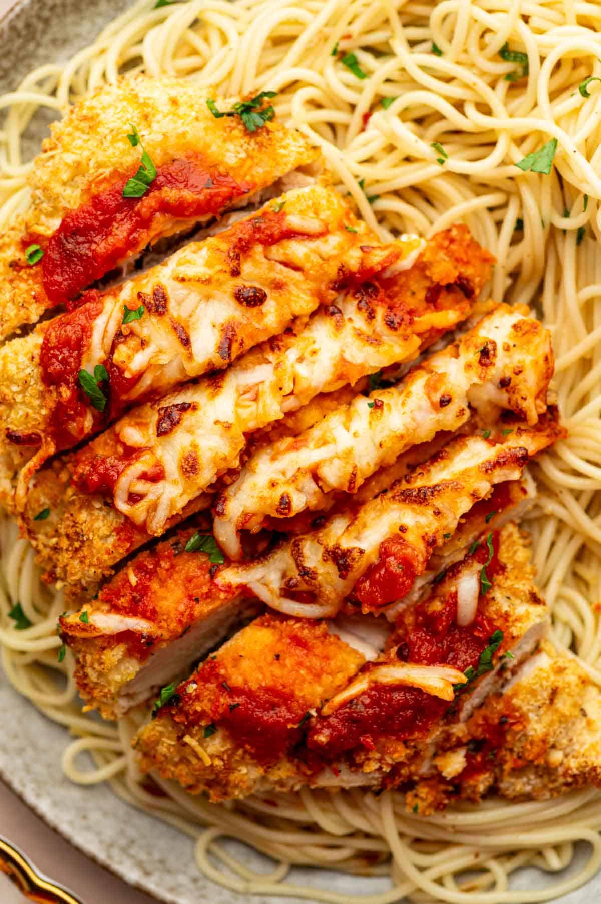 Close-up golden crust on chicken parmesan with Parmesan sprinkle