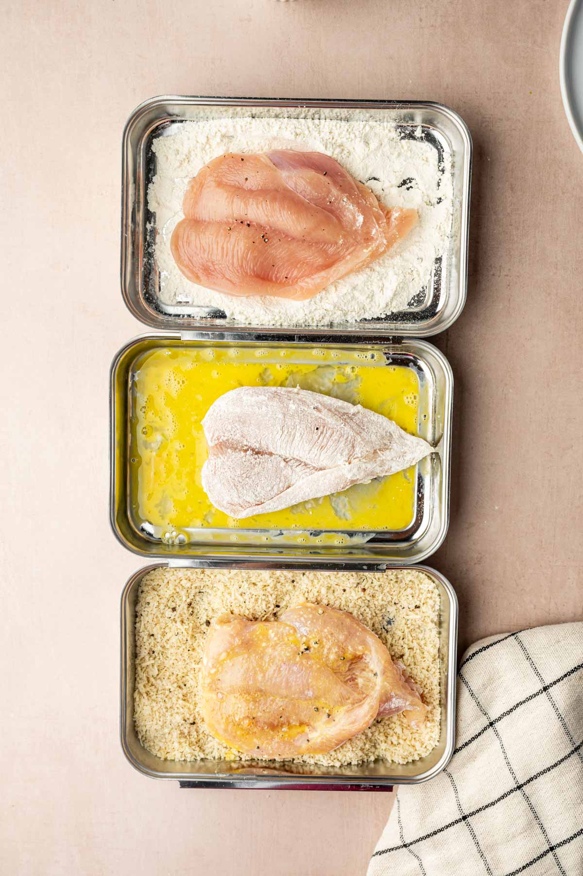 Dredging thin chicken cutlet in flour before egg wash and then in panko bread crumbs.