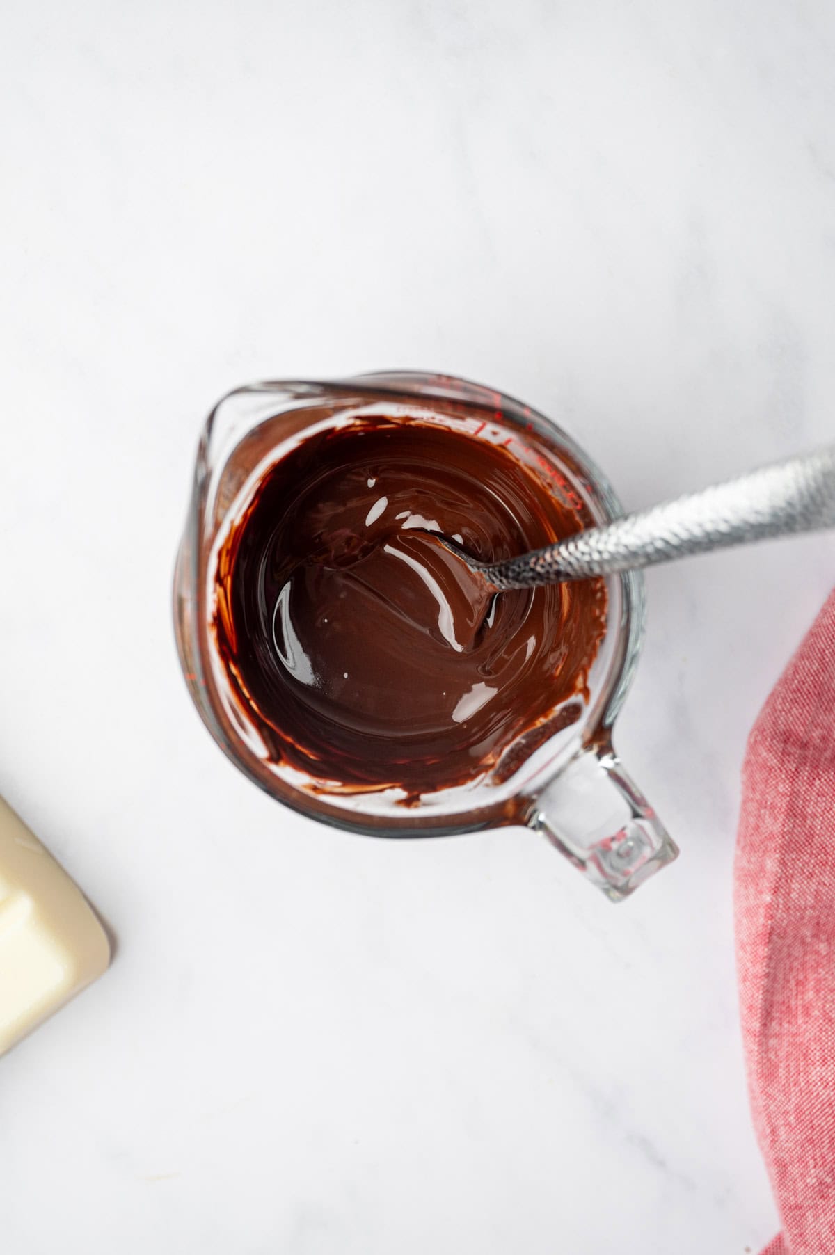 Melted chocolate in a glass jar with spoon.