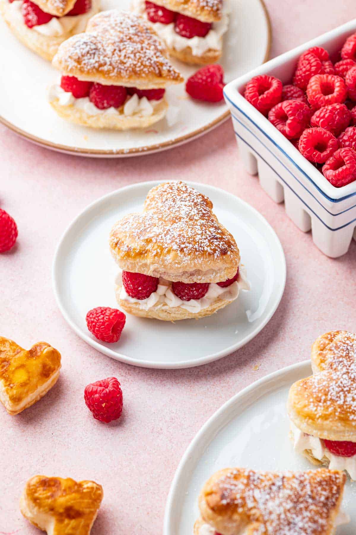 Puff pastry hearts filled with whipped cream and fresh raspberries dusted with powdered sugar.