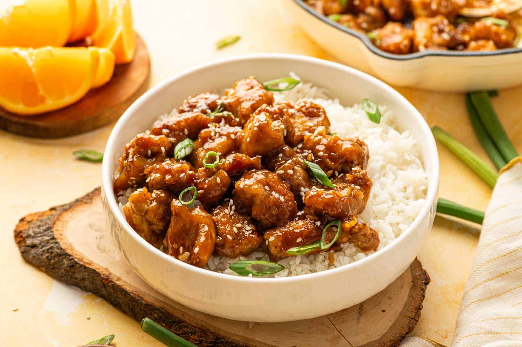 Crispy orange chicken thigh bites tossed in orange sauce over steamed rice