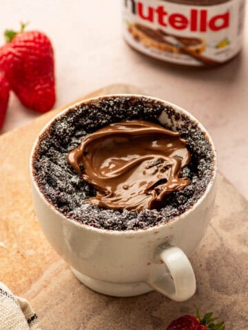 Chocolate Nutella mug cake in a mug with gooey middle, quick microwave dessert.