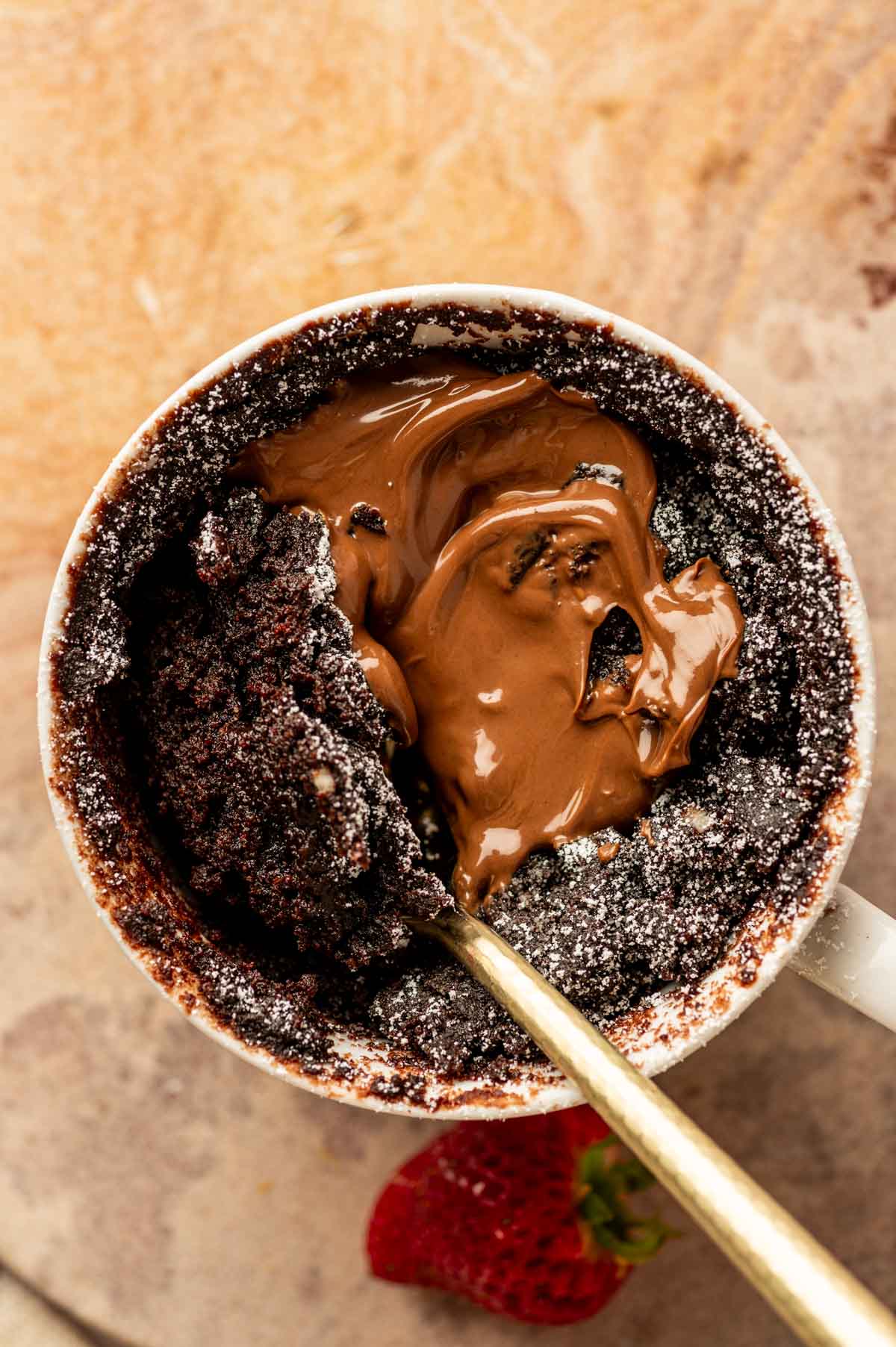 Spoonful of gooey Nutella mug cake showing soft, fudgy texture.
