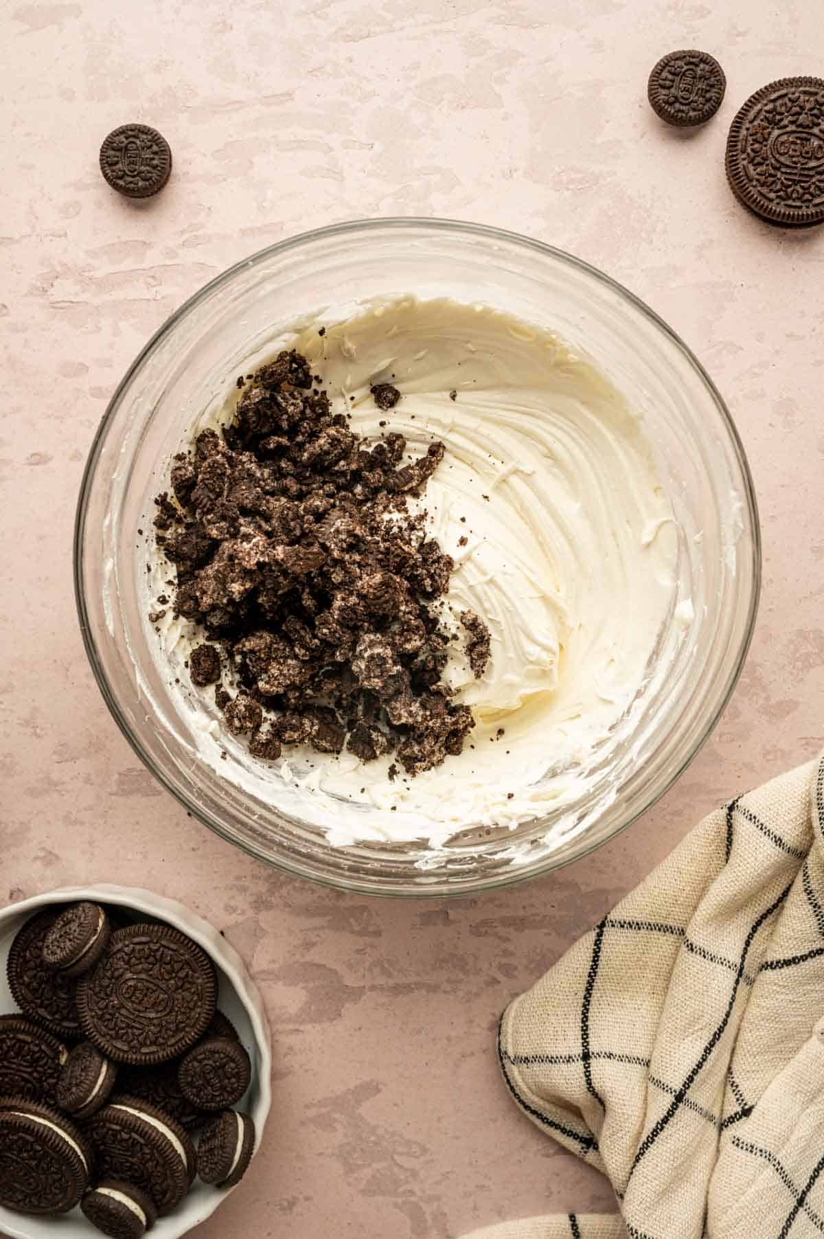 Crushed Oreos being added to the cream mousse mixture