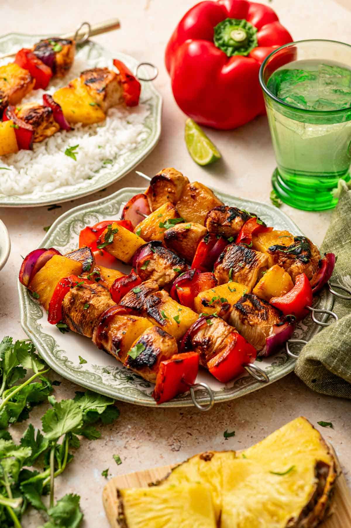 Pineapple chicken kabobs with charred edges served with lime wedges