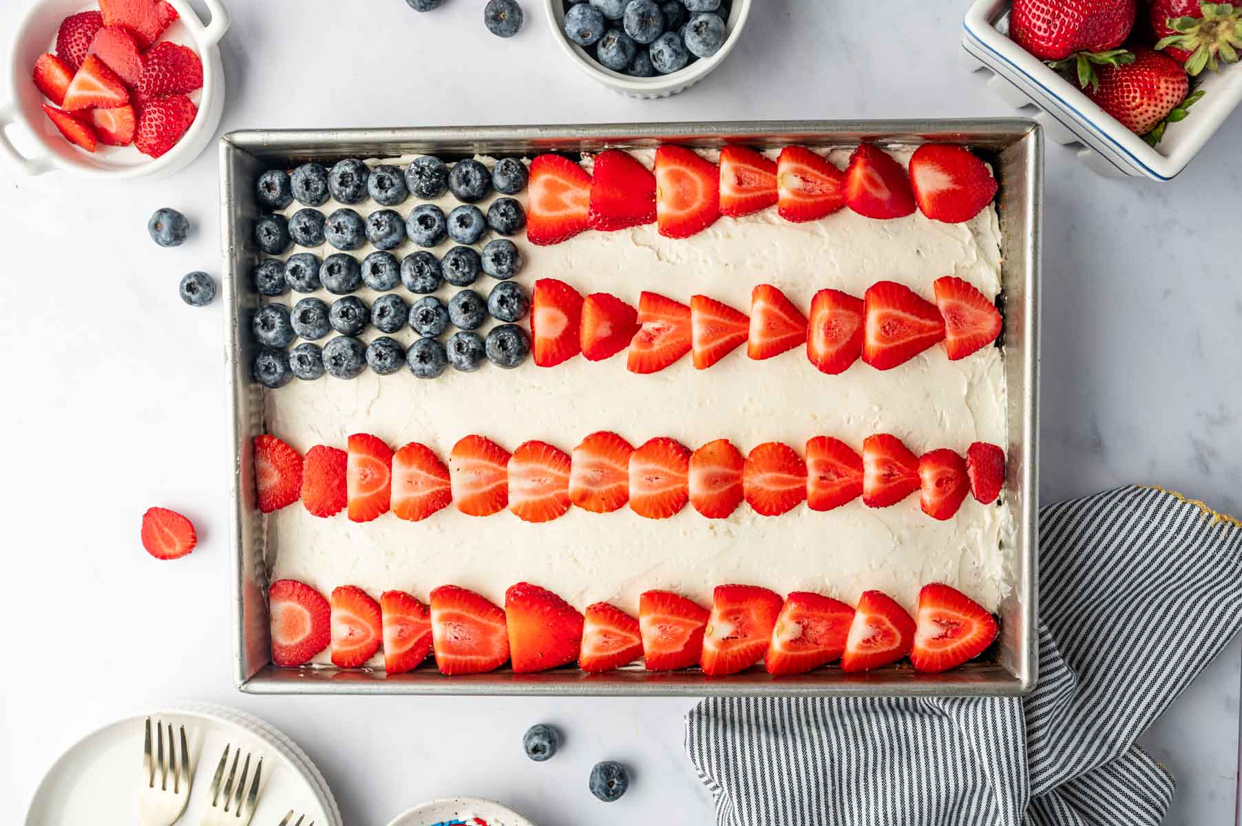 Patriotic flag cake recipe decorated with fresh strawberries and blueberries on top of the cake
