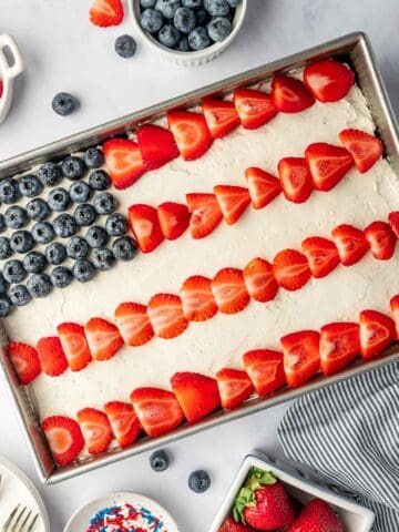 Patriotic flag cake recipe decorated with fresh strawberries and blueberries on top of the cake