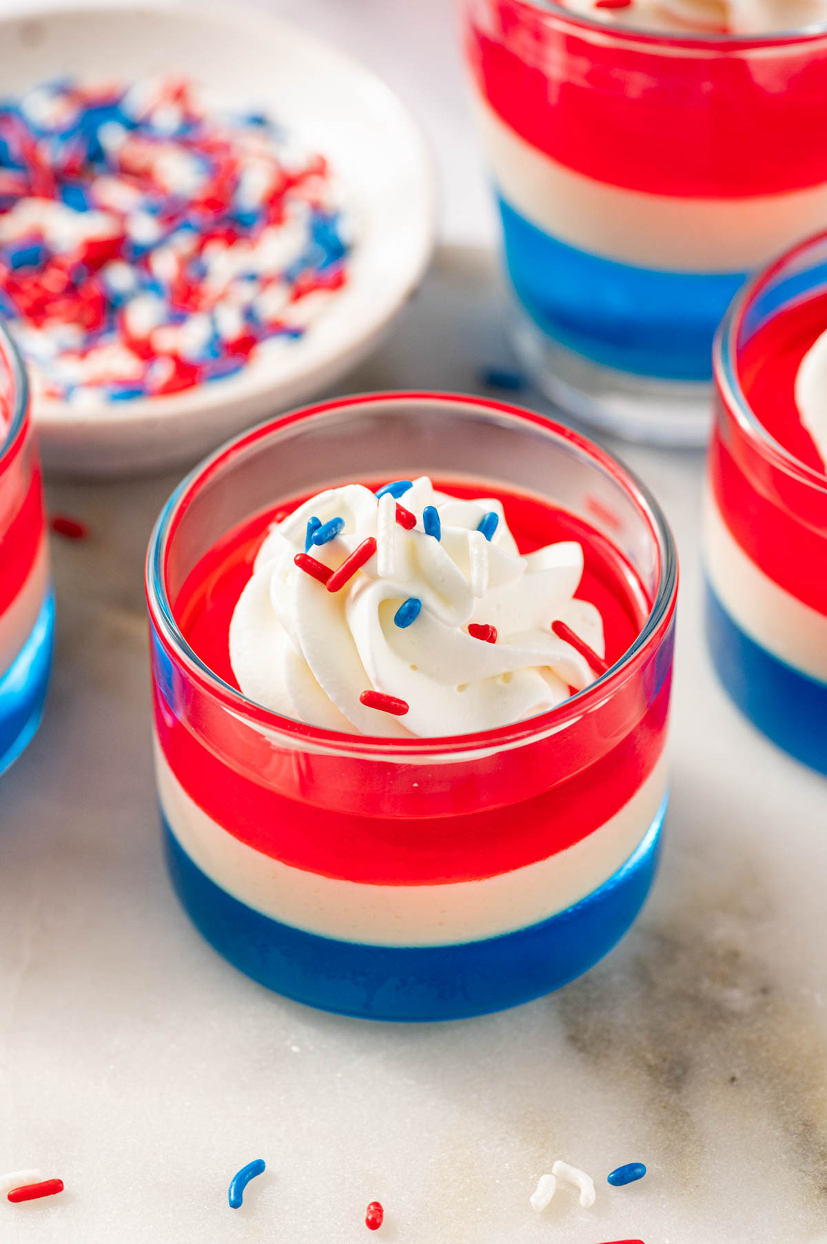 Close up of layered fourth of july jello shots with whipped cream topping