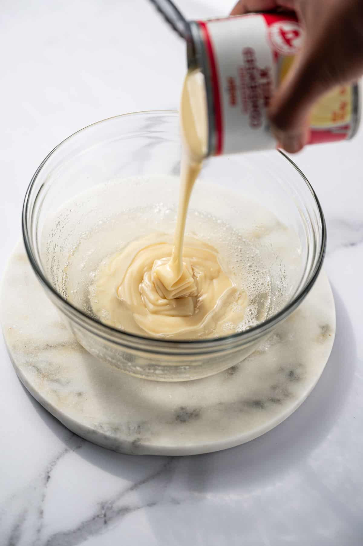 Condensed milk being added to the gelatin bowl