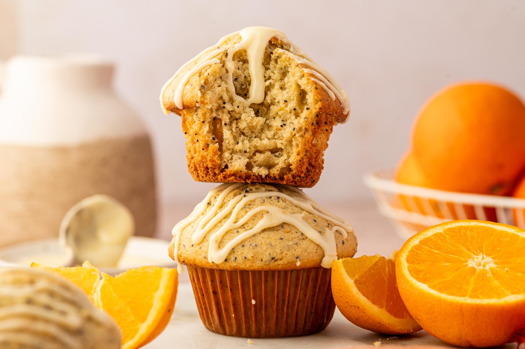 Close up shot of orange poppy seed muffins showing the texture and drizzle of orange icing on top.