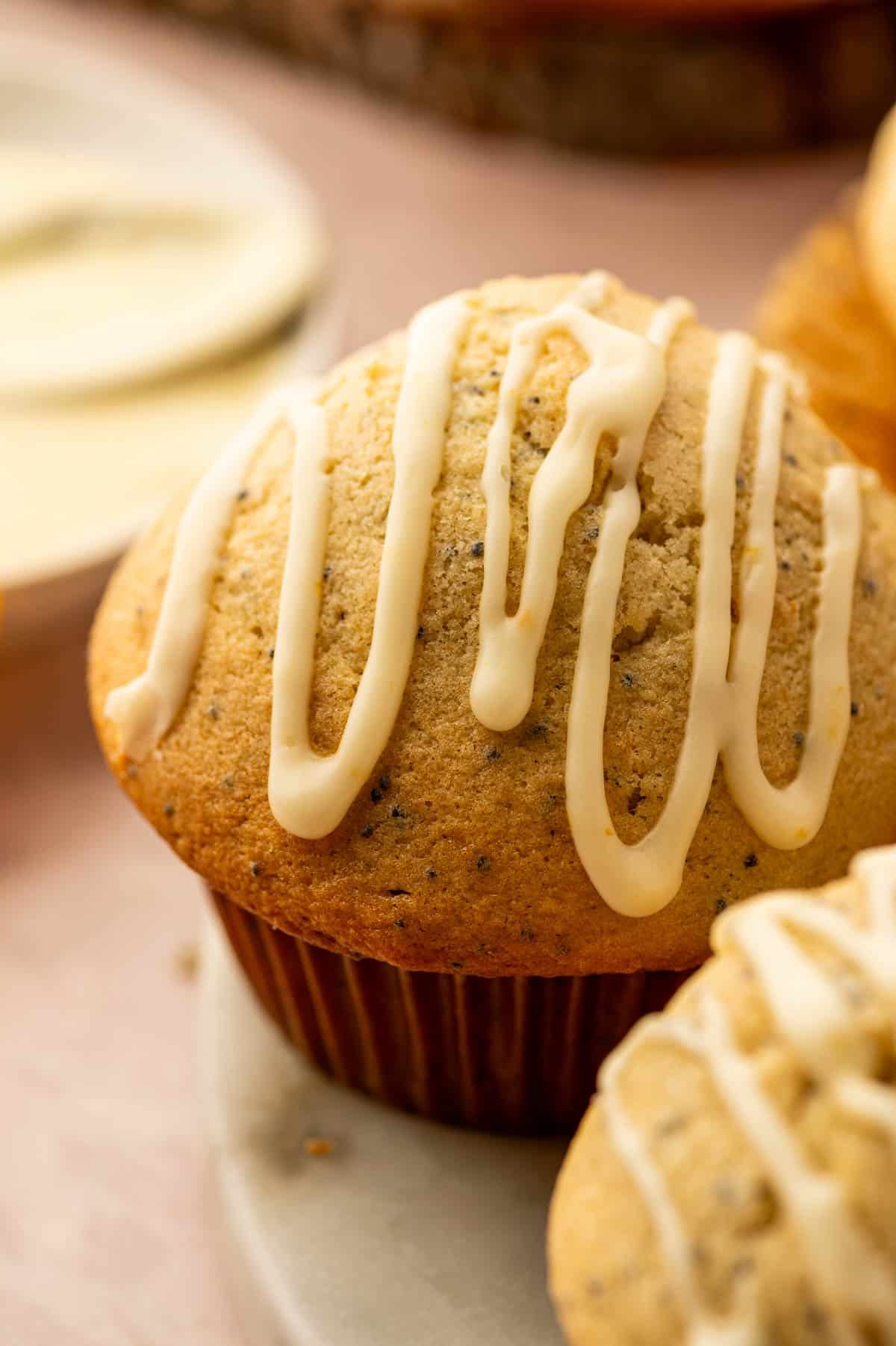 Close up shot of Top-down view of orange poppy seed muffins with glossy orange glaze