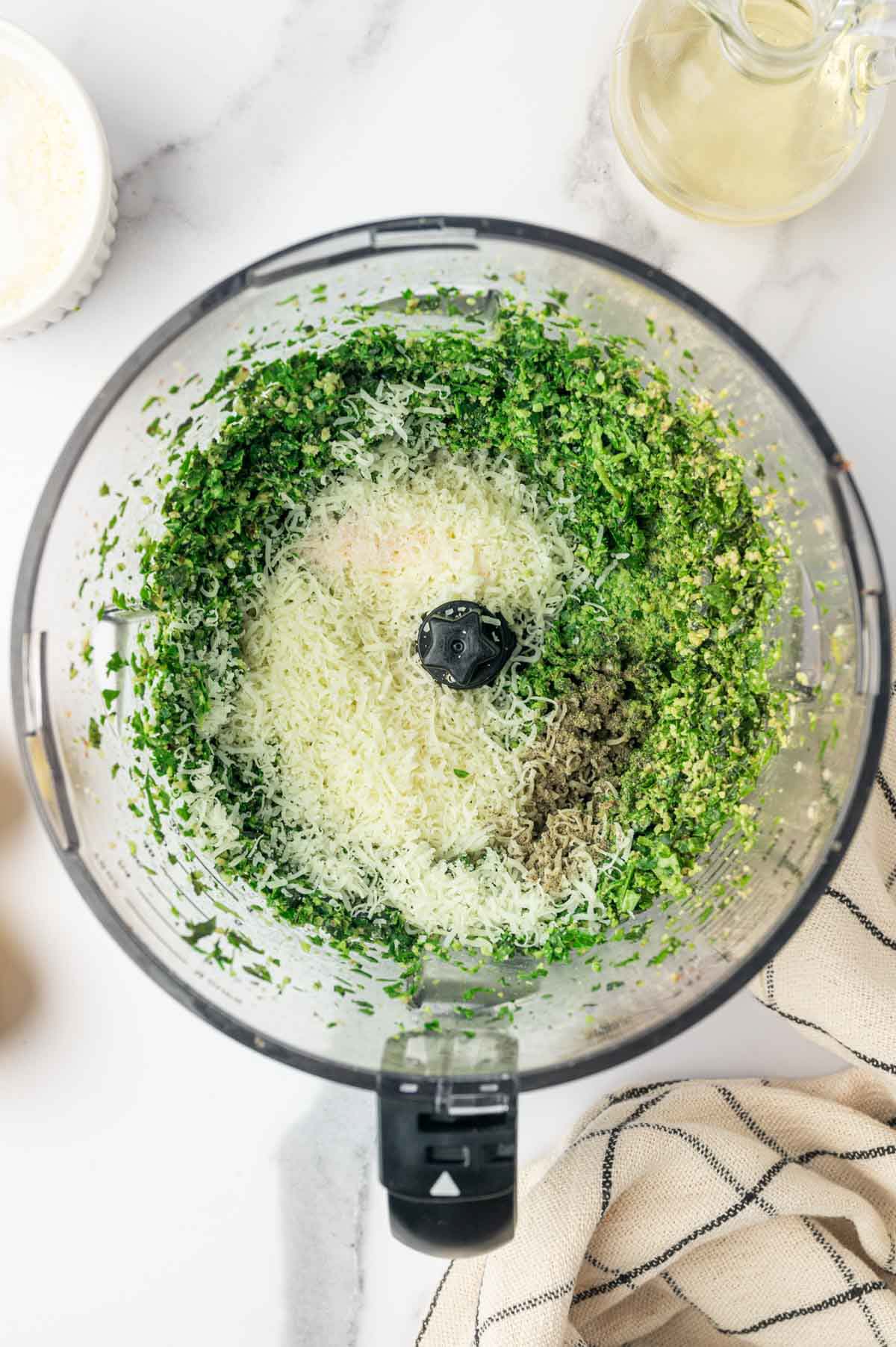 blending pesto with basil, parmesan cheese, pepper, oil in a food processor