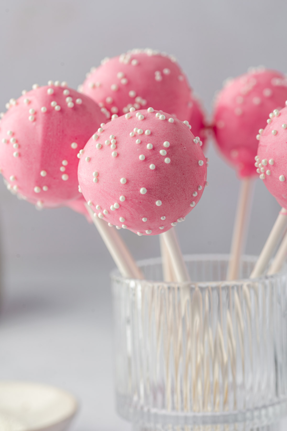 Starbucks copycat birthday cake pops decorated with pink frosting and white ball sprinkles