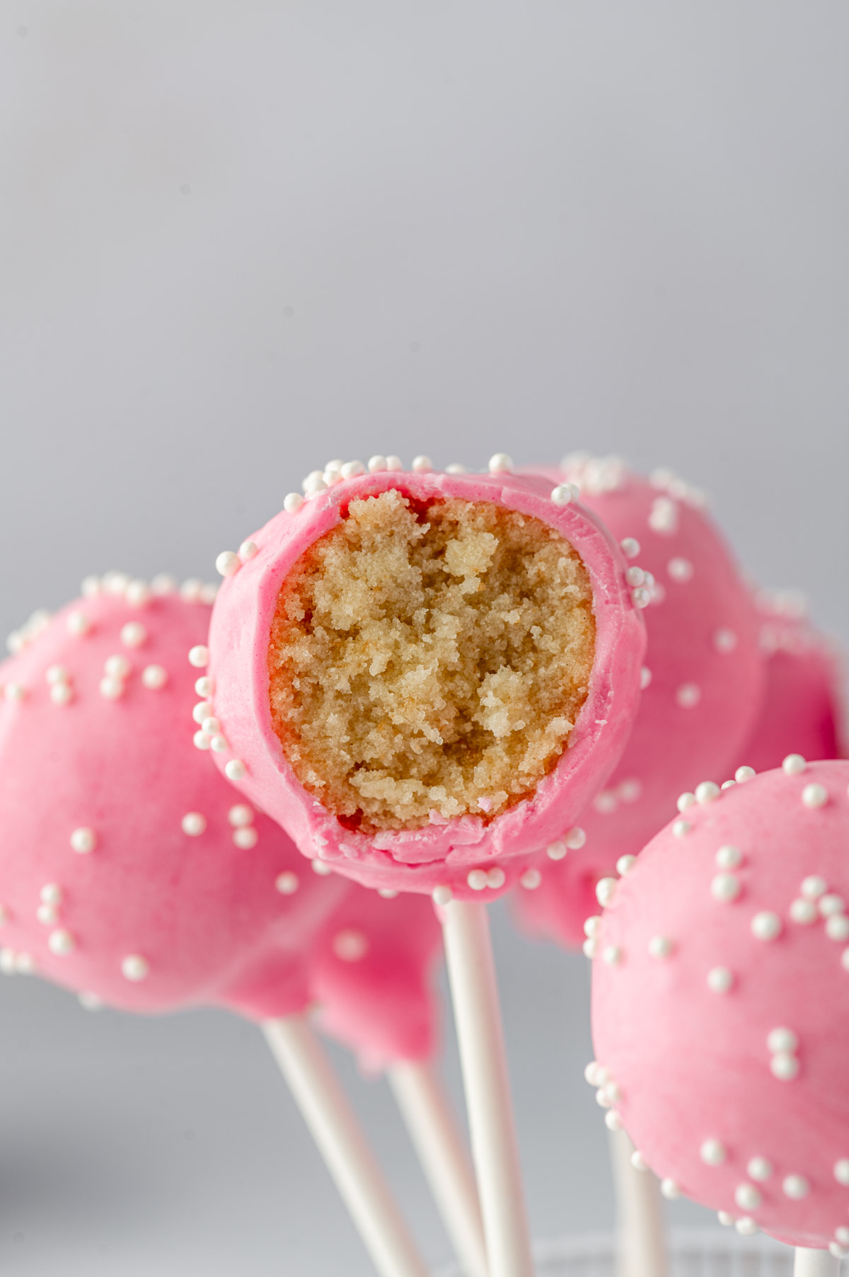 A bite taken from the Starbucks-inspired birthday cake pop with pink candy coating and sprinkles