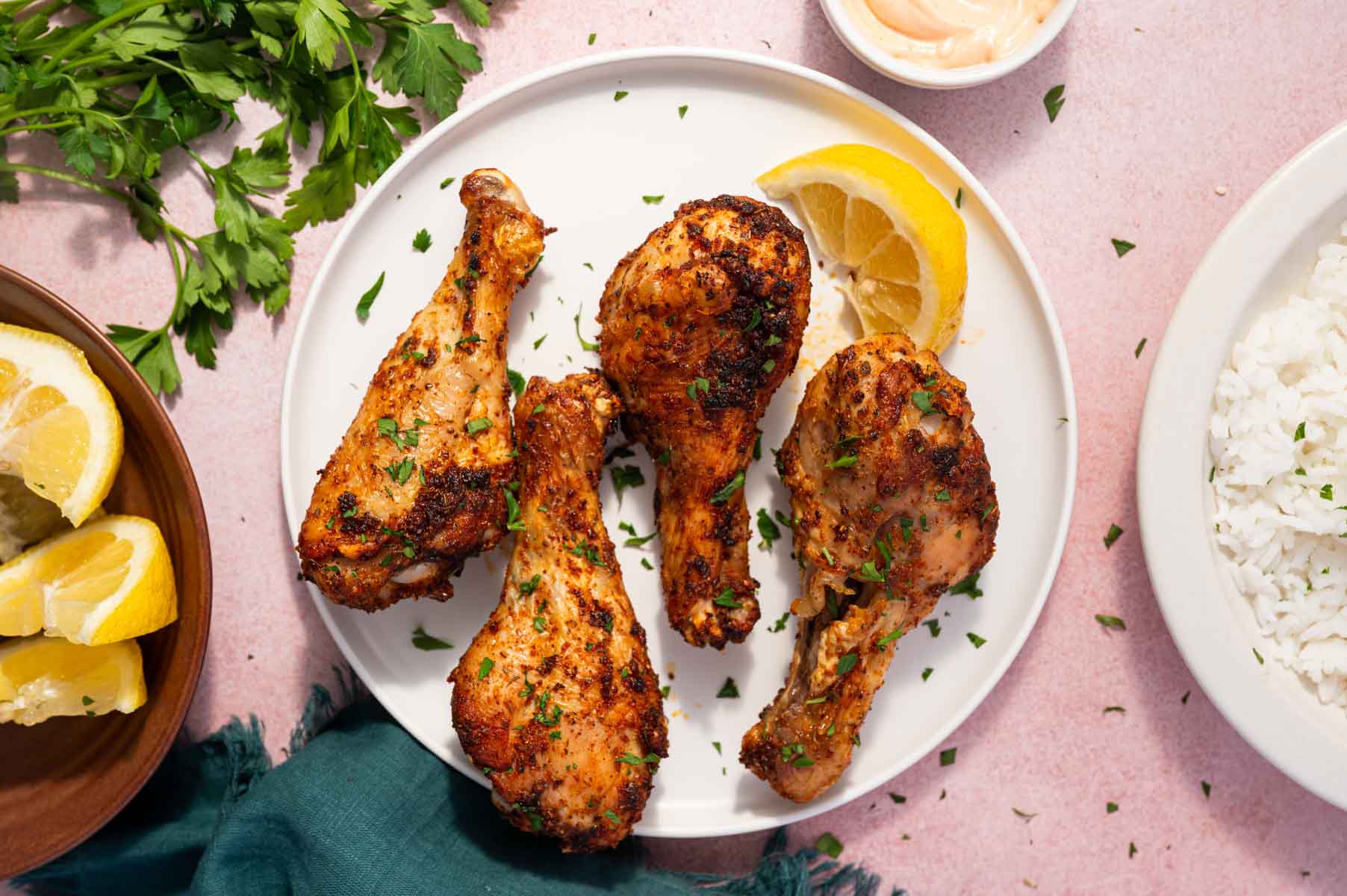 Air fryer chicken drumsticks with perfectly crisp skin and juicy interior placed in a white plate.