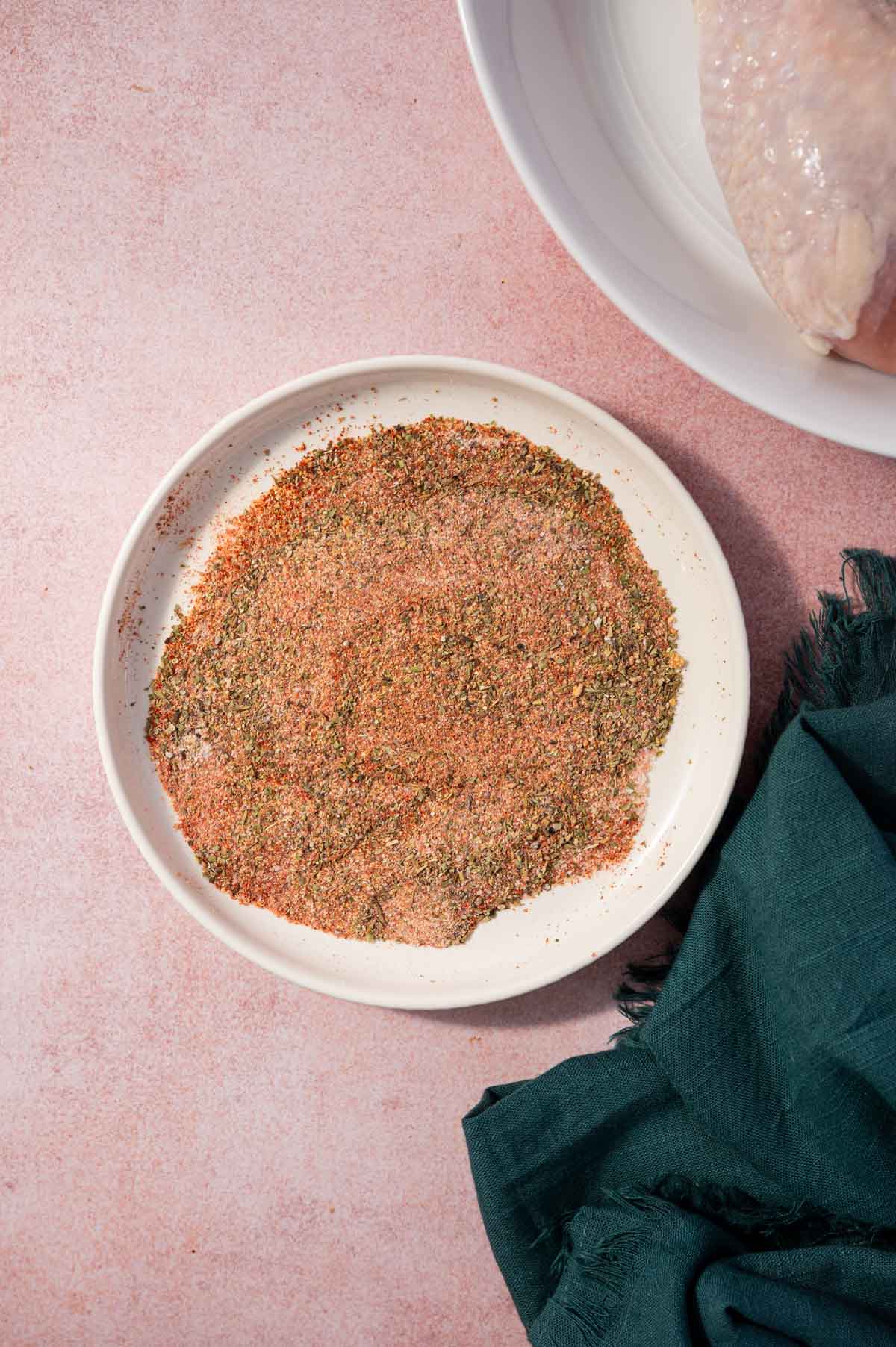 Seasonings mixed in a white plate to make air fryer chicken drumsticks.