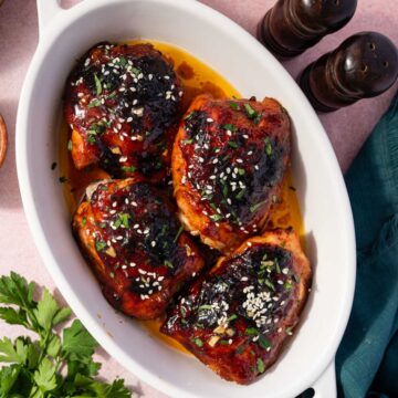 Oven baked honey garlic chicken thighs with sticky glaze in a baking dish